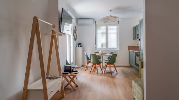 A modern kitchen with a dining area, wooden floor, and a TV mounted on the wall. - Town house + Parking and garden 5 min Bretonneau Tours center (Tours)