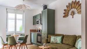 A compact living space with a dining area, kitchenette, and a sofa with cushions. - Town house + Parking and garden 5 min Bretonneau Tours center (Tours)