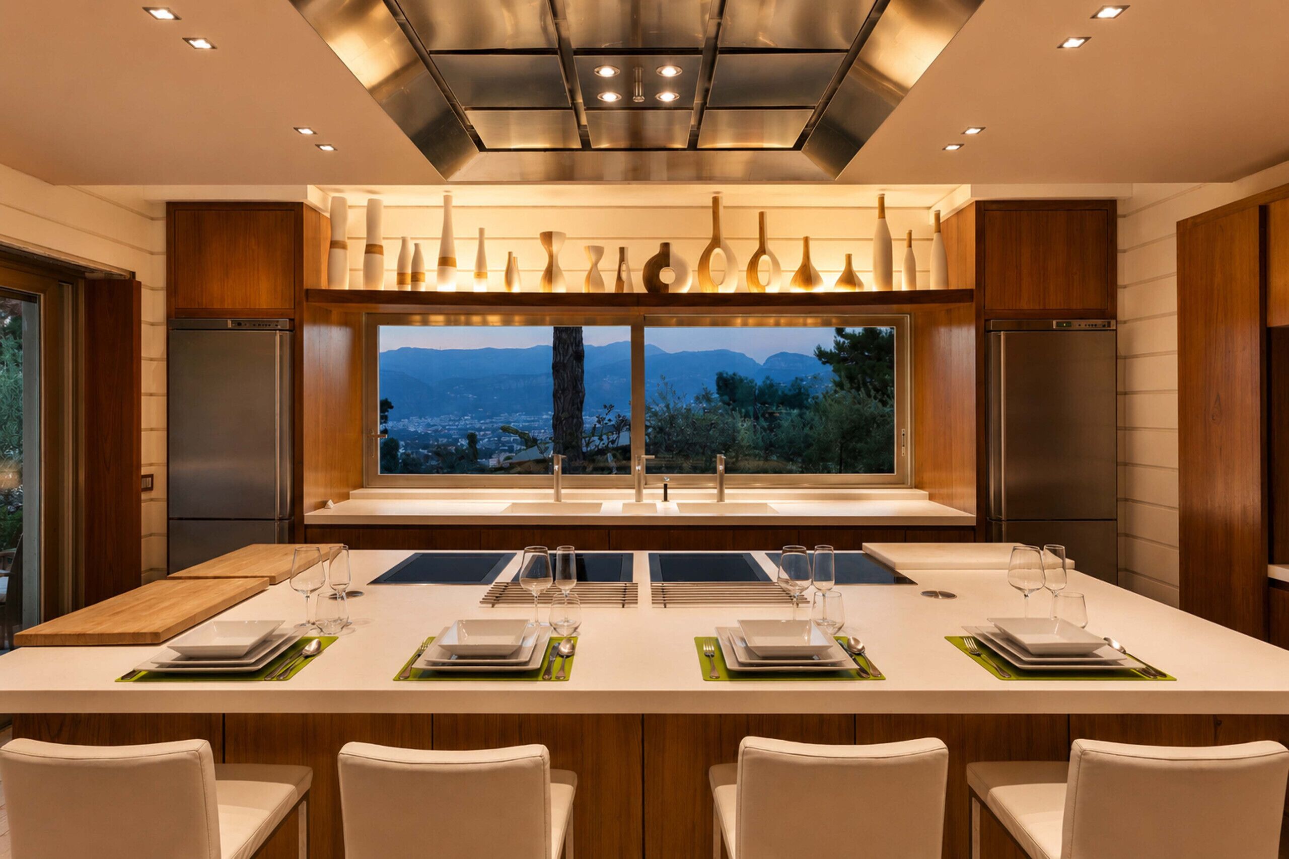 A modern kitchen with a large island, stainless steel appliances, and a view of the mountains.