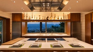 Una cocina moderna con una isla grande, electrodomésticos de acero inoxidable y vistas a la montaña.