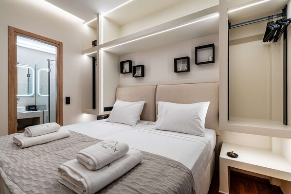 A modern hotel room with a large bed, a built-in wardrobe, and a mirror. - Apex B1 - Modern City Stay in Central Pangrati (Athens)