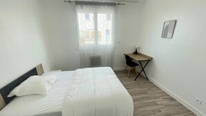A bedroom with a bed, a desk, and a window. - Spacious apartment near downtown (Avignon)
