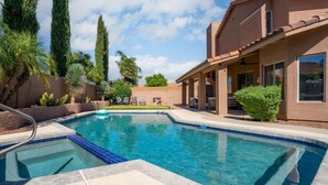 A swimming pool with a tiled edge, lounge chairs, and a covered patio area. - Kierland Golf Retreat | Pool, Spa, 4 Kings (Scottsdale)