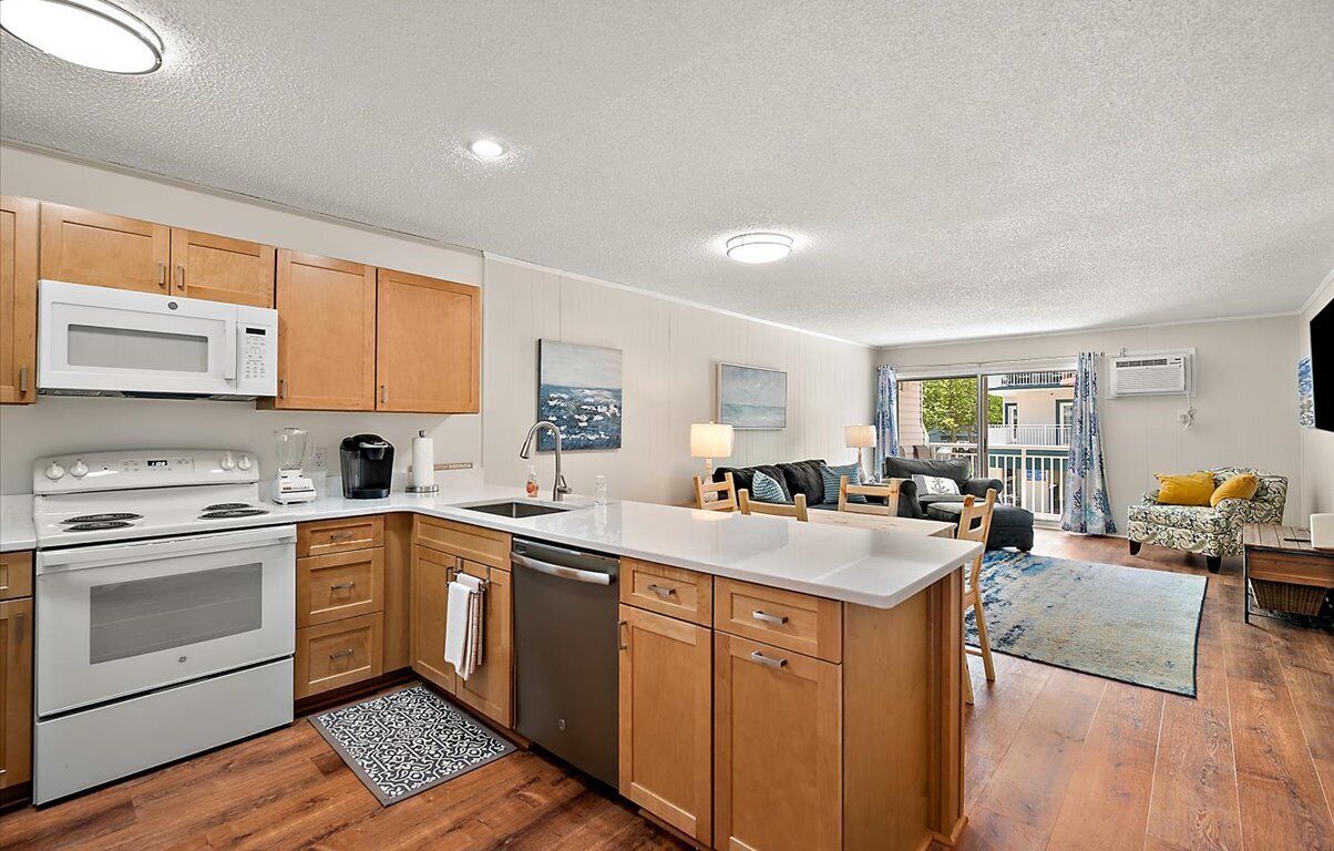 A modern kitchen with wooden cabinets, a white stove, and a dishwasher.