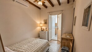 Ein Schlafzimmer mit einem Bett, einem Schminktisch, einem Spiegel und einer Tür zu einem Badezimmer.