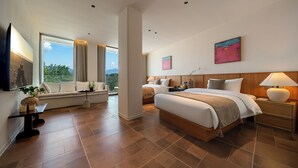 Una habitación de hotel moderna con una cama grande, un sofá, un televisor y una ventana con cortinas.