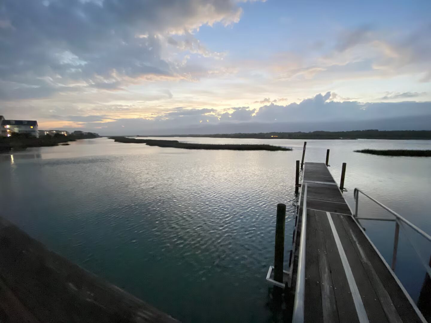 Una orilla tranquila con un muelle de madera que se adentra en el agua.