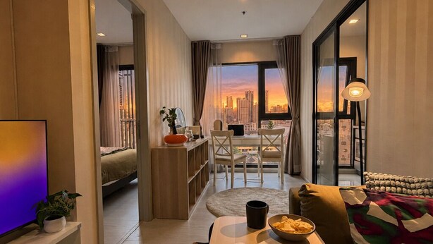 Ein modernes Wohnzimmer mit Stadtblick, einem Essbereich und einem Fernseher links.