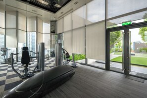 A gym with exercise equipment, large windows, and a checkered floor. - 5 min to BTS Fully Equipped Kitchen with City View (Khet Khlong Toei)