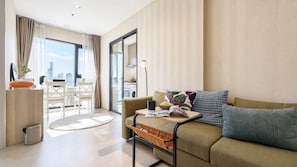 Ein modernes Wohnzimmer mit einer Couch, einem Couchtisch und einem Essbereich mit Tisch und Stühlen.