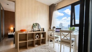 Ein modernes Hotelzimmer mit Schreibtisch, Laptop und Blick auf die Stadt.
