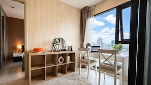 Ein modernes Hotelzimmer mit Schreibtisch, Laptop und Blick auf die Stadt.