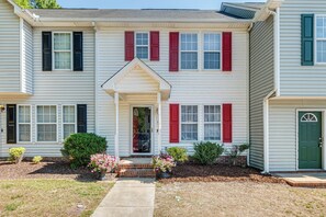 A two-story house with a front porch, red shutters, and a green door. - Great for Families! Raleigh Townhome 5 Mi to Dtwn (Raleigh)