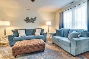 A living room with two sofas, a tufted ottoman, and two lamps. - Great for Families! Raleigh Townhome 5 Mi to Dtwn (Raleigh)