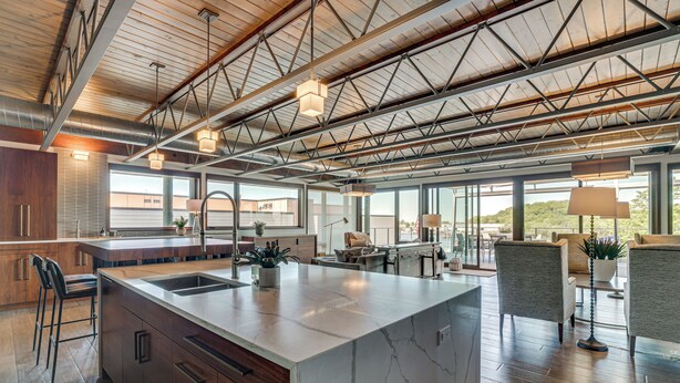 Una cocina amplia con una isla grande, electrodomésticos modernos y vistas al exterior.