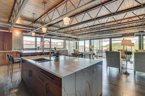A spacious kitchen with a large island, modern appliances, and a view of the outdoors. - Grand Haven Condo w/ Channel View & Dtwn Location (Grand Haven)