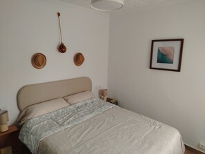 A neatly made bed with a beige headboard, two bedside tables with lamps, and a framed picture on the wall. - Maison typique de San Pedro del Pinatar : Plages et toutes commodités à pied ! (San Pedro del Pinatar)