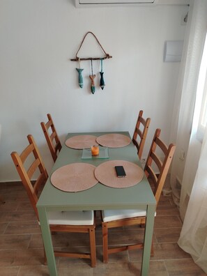 A dining table with four chairs, a glass top, and placemats. - Maison typique de San Pedro del Pinatar : Plages et toutes commodités à pied ! (San Pedro del Pinatar)