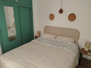 A bedroom with a bed, a mirror, two bedside lamps, and a green wardrobe. - Maison typique de San Pedro del Pinatar : Plages et toutes commodités à pied ! (San Pedro del Pinatar)