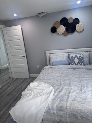 Ein Schlafzimmer mit einem Bett, einer weißen Tür und einem Wanddekor.