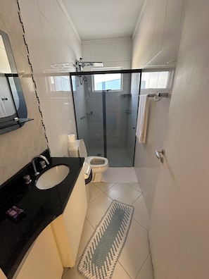 A modern bathroom with a black sink, white toilet, glass shower enclosure, and a small window. - Recanto Luna foz (Foz do Iguaçu)