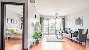 Ein modernes Wohnzimmer mit einer Couch, Sesseln, einem Couchtisch und einer Topfpflanze.