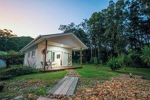 A small house with a porch, surrounded by a garden and trees. - The Poolhaus Retreat- Peaceful private guesthouse (Valdora)