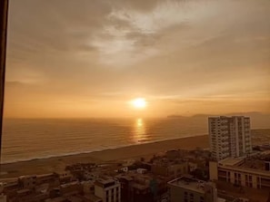 A coastal cityscape with buildings near the beach during sunset. - Apartment with a view of the Magdalena del Mar, Lima (Lima)