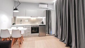 Una cocina moderna con comedor, armarios blancos y horno empotrado.