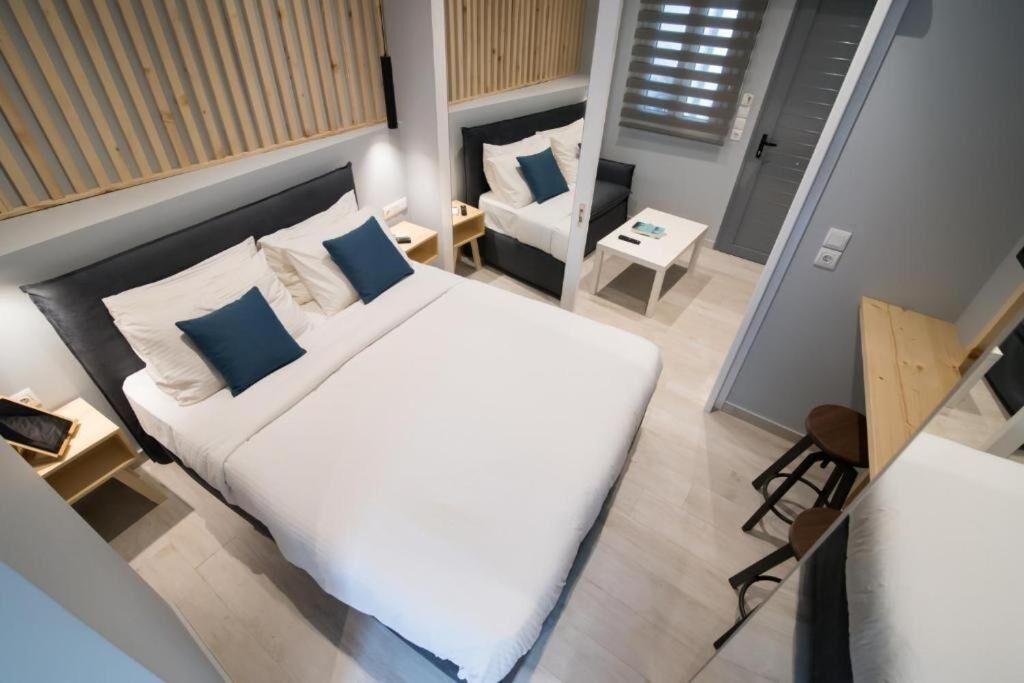 A modern hotel room with a large bed, bedside tables, a small desk, and a chair.