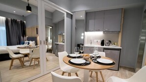 Una habitación de hotel moderna con comedor, kitchenette y cama con vistas.