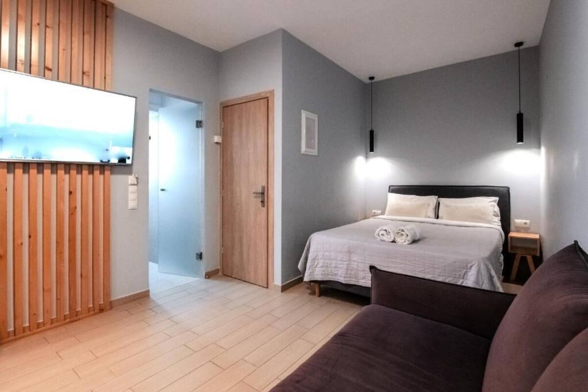A bedroom with a bed, bedside table, and a wooden panel wall.