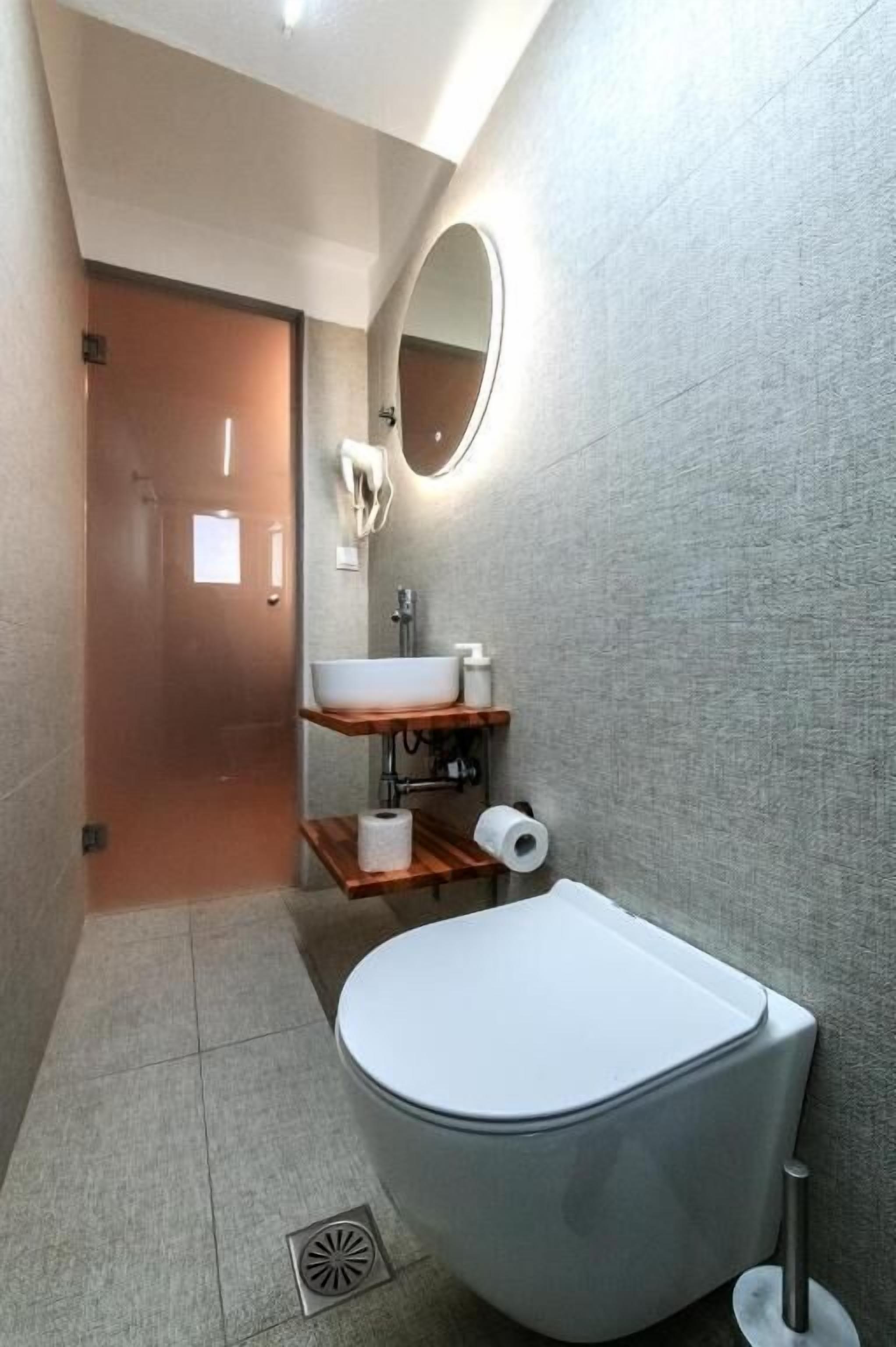 Un baño con inodoro, lavabo y espejo.