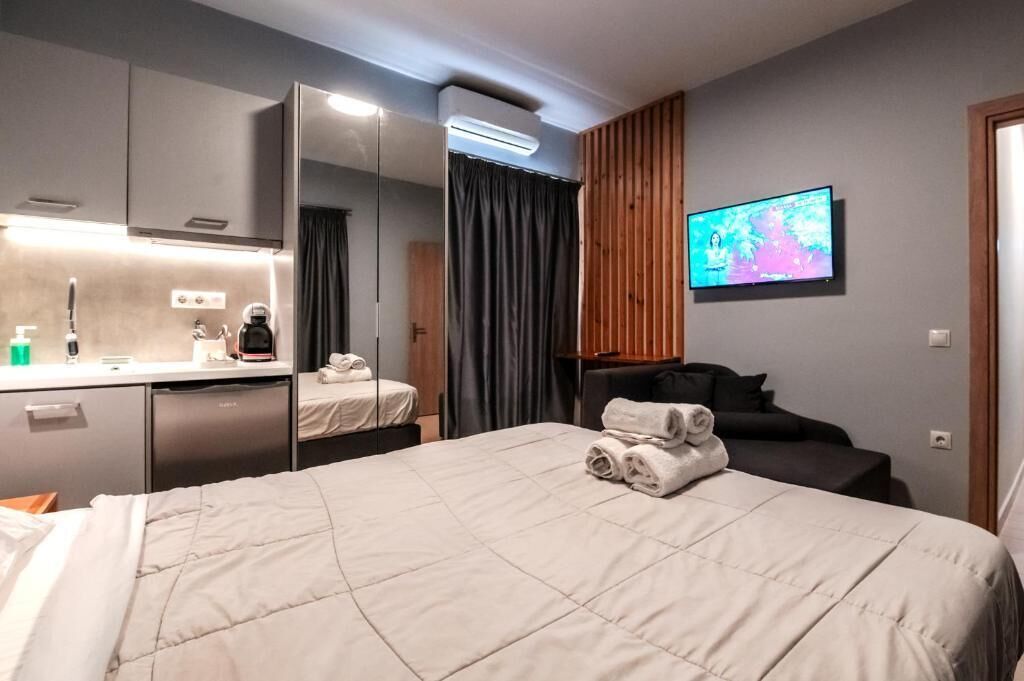Une chambre d’hôtel comprenant un lit, un bureau avec un miroir, une télévision et une salle de bain.