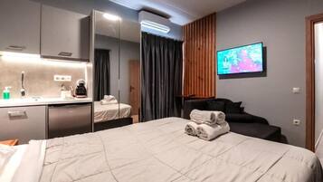 Une chambre d’hôtel comprenant un lit, un bureau avec un miroir, une télévision et une salle de bain.