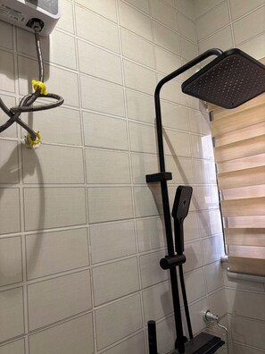 A bathroom with a shower, tiled walls, and a window with blinds. - Beautiful 2-bedroom terrace with AC and fan in all rooms in a gated community. (Amrahia)