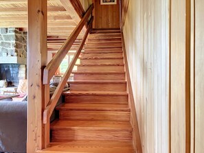 Eine Holztreppe mit Handlauf, die zu einer Steinmauer führt.