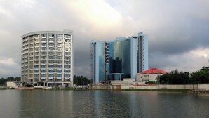 Ein Hotel am Wasser mit modernem Design, das eine geschwungene Fassade und eine markante Glasarchitektur aufweist.