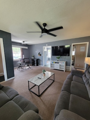 A living room with a ceiling fan, a TV, a coffee table, and a sofa. - Canyon Lake GETAWAY 2 bedrooms-1-KING & 1 QUEEN (Rapid City)