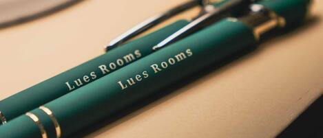 Un bolígrafo verde con la inscripción 'Lues Rooms'.