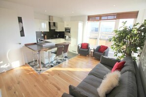 A modern apartment with a kitchen, dining area, and living room. - The Luxurious Penthouse (Cambridge)