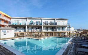 A hotel with a pool, outdoor seating, and balconies. - Bayfront 2BR Condo with Water Views (Ocean City)