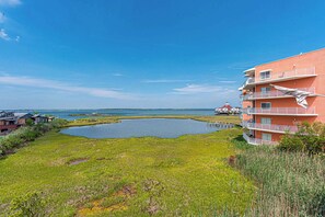 A coastal building with balconies overlooking a body of water. - Bayfront 2BR Condo with Water Views (Ocean City)