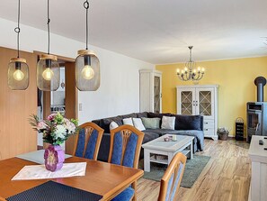 Ein Essbereich mit Holztisch, Stühlen und Pendelleuchten.