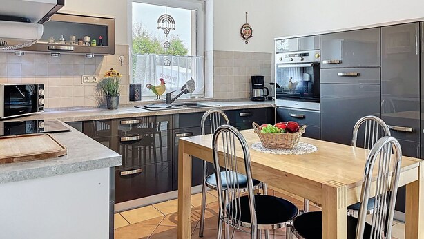 A modern kitchen with a dining area, including a stove, oven, and refrigerator. - Stunning private villa for 6 guests with WIFI, TV, patio and panoramic view (Greifswald)