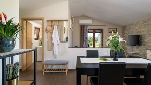 A modern kitchen with a dining area, a bench, and a TV mounted on the wall. - Stunning private villa for 6 guests with WIFI, private pool, A/C, TV and terrace (Vodnjan)