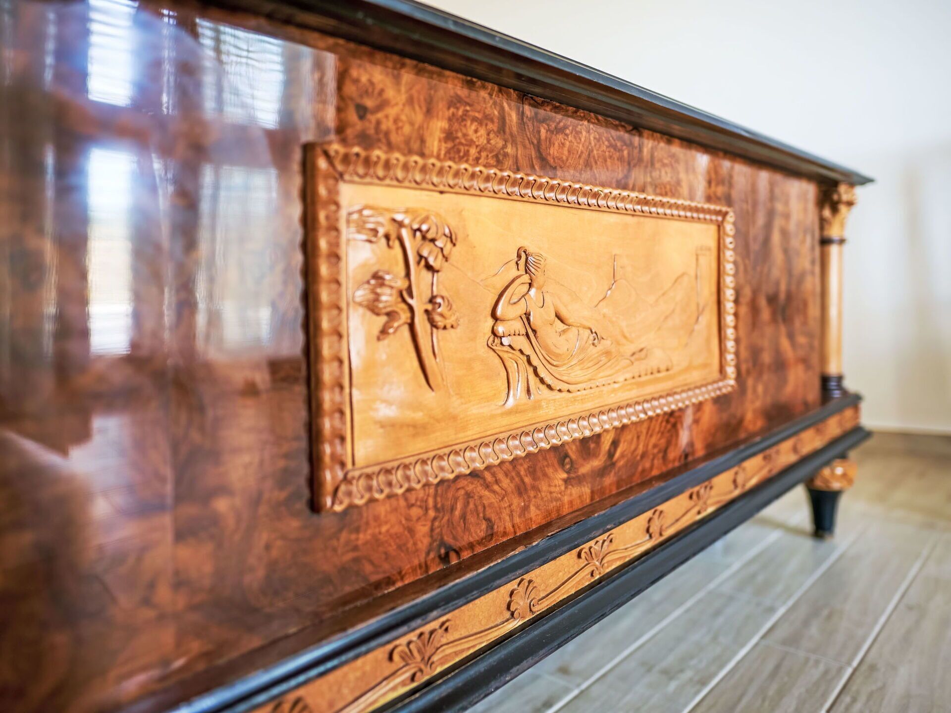 A wooden cabinet with intricate carvings and a decorative border.
