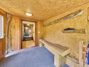 Ein Zimmer mit einer hölzernen Bank, einer Steinwand und einer Holztür.