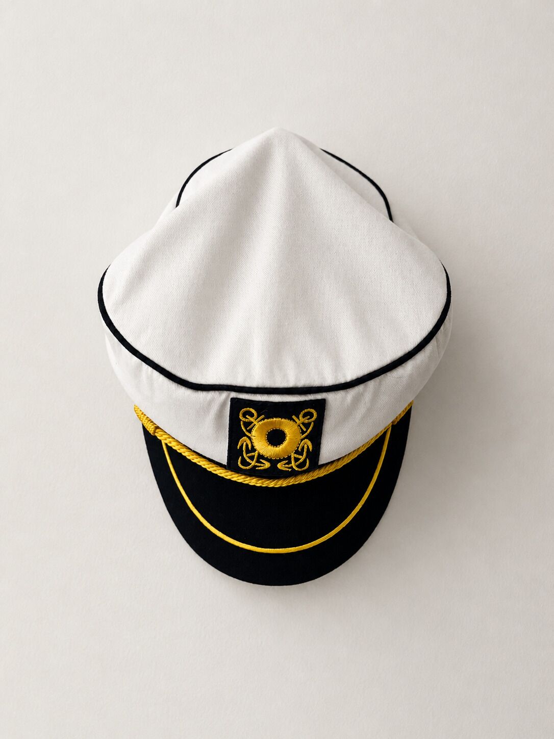 A white and black cap with a gold emblem.