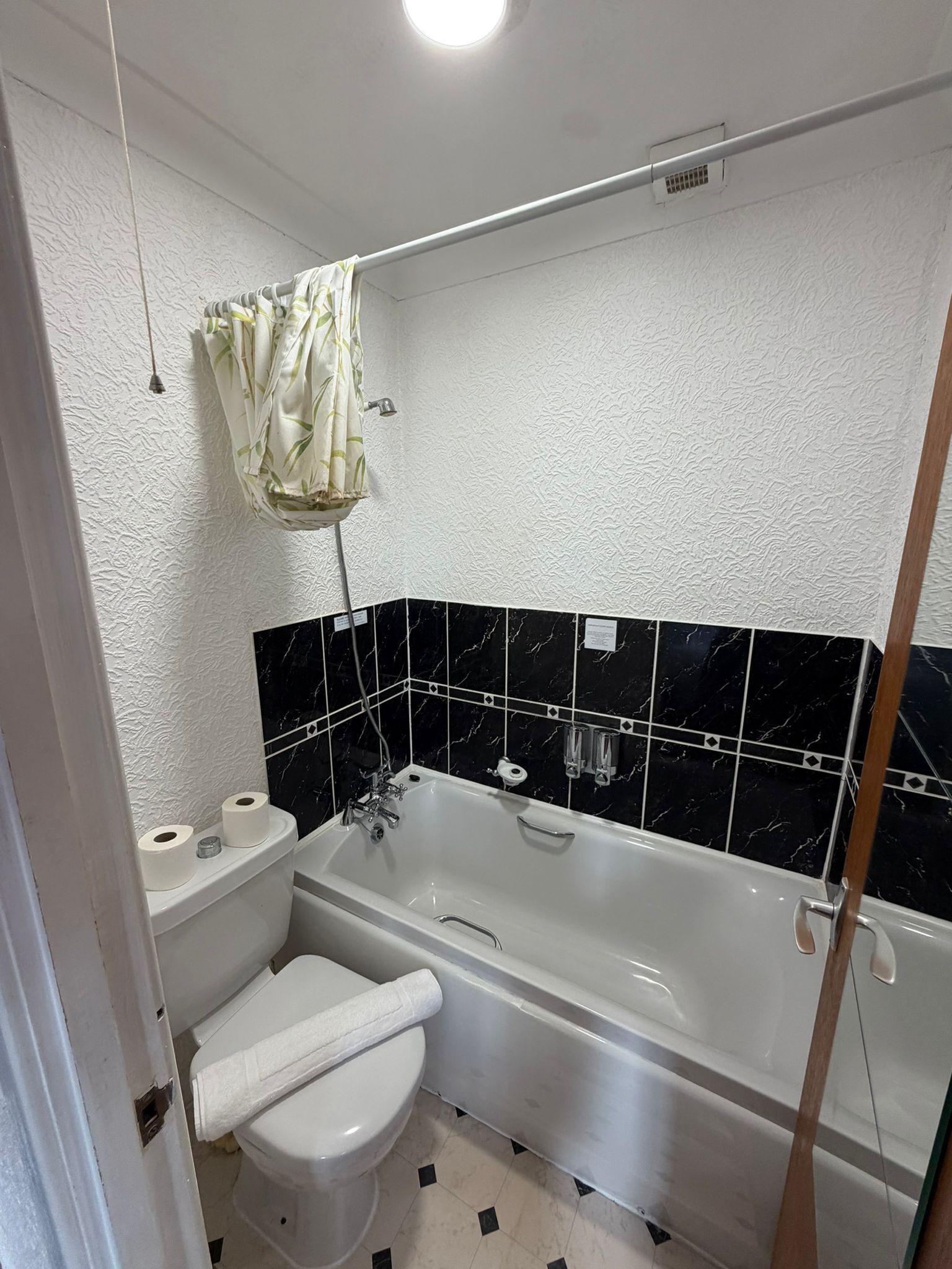Un baño con inodoro, bañera y cortina de ducha.